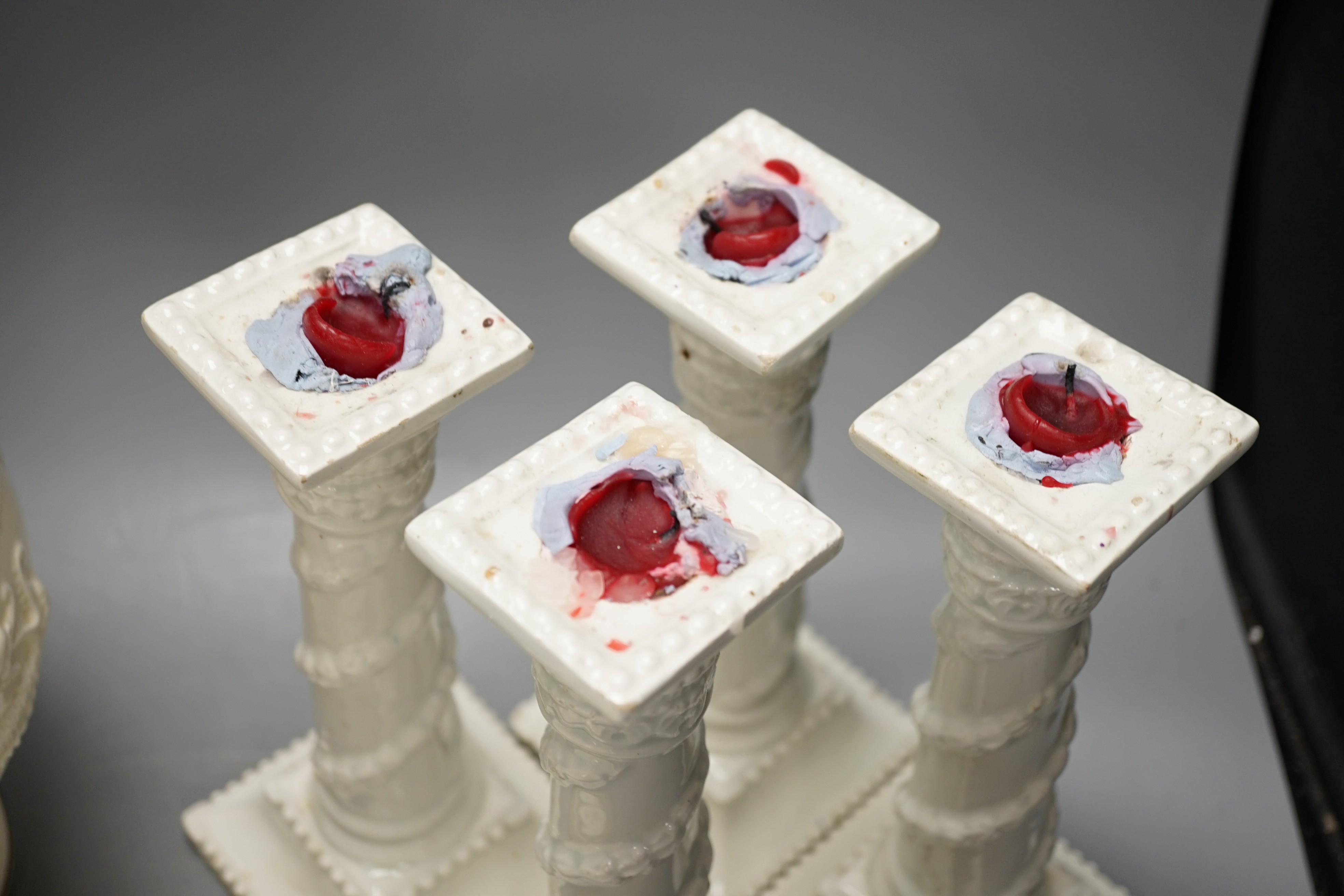 A set of seven early 19th century creamware plates, four later creamware candlesticks and an ivory ground jug. Tallest piece 33cm